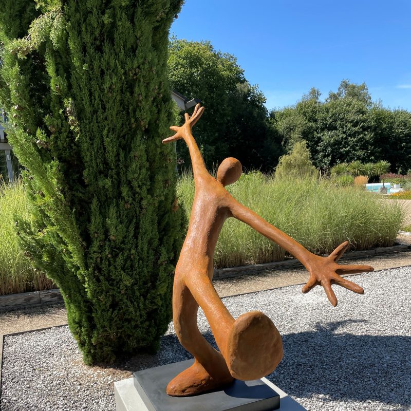 Figure with arms wide open and leg out in metal 
