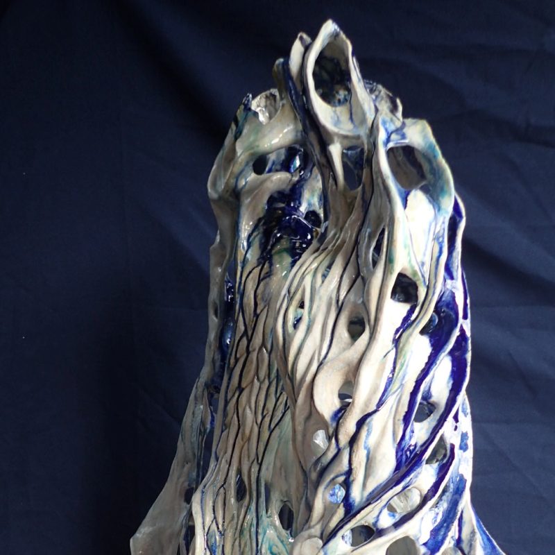 White ceramic shell-like cascading form with blue flecks 