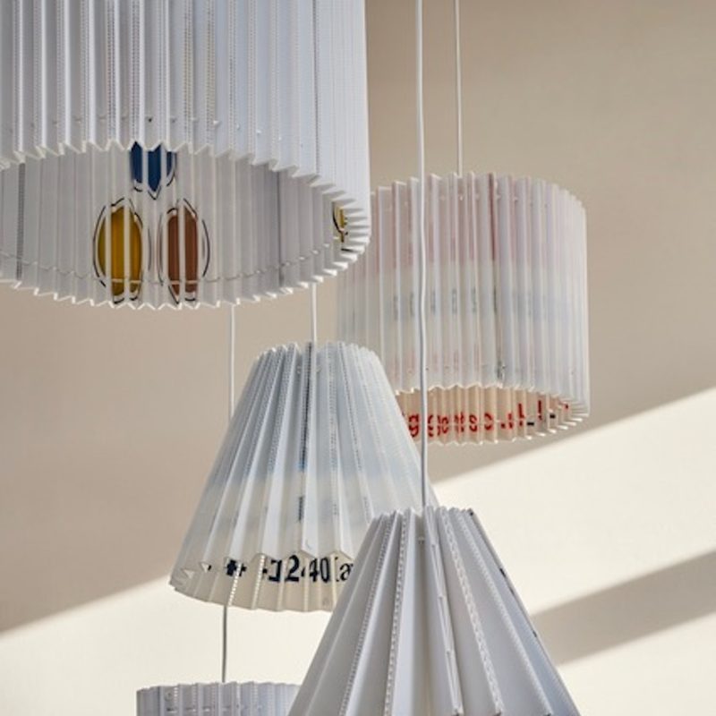 Handmade pleated lampshades made from discarded materials.