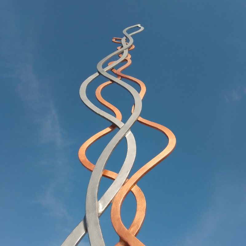 Intertwined metal ripples and twists reaching vertically into the sky 